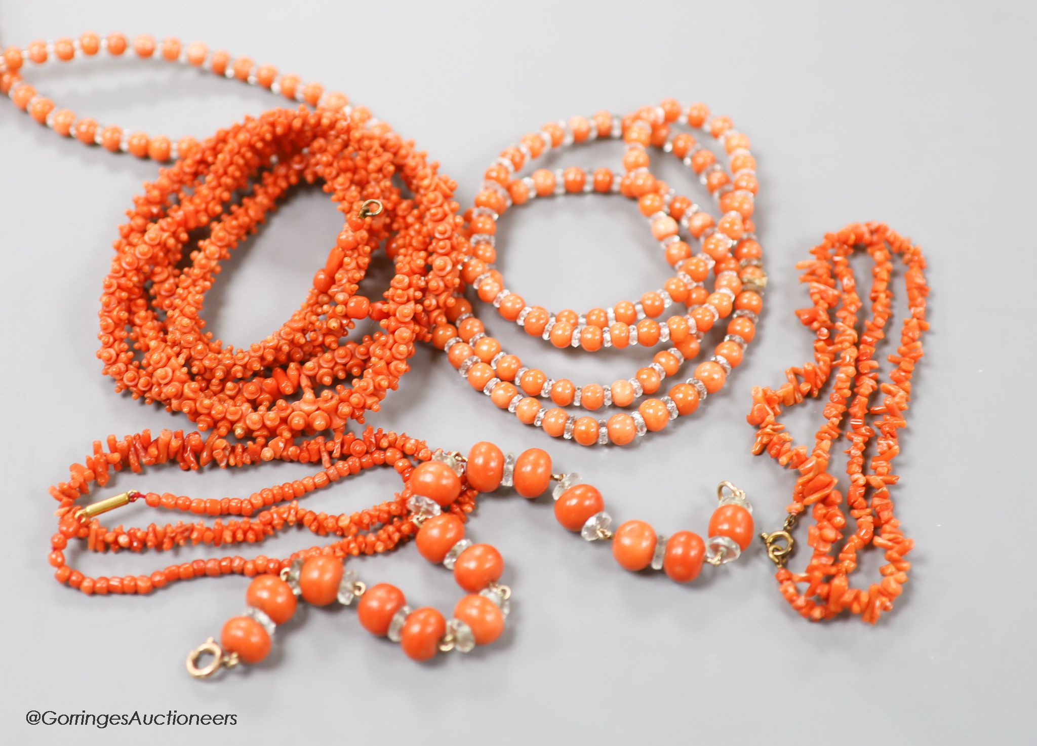 Four assorted coral bead necklaces, largest 148cm and a coral bead bracelet.